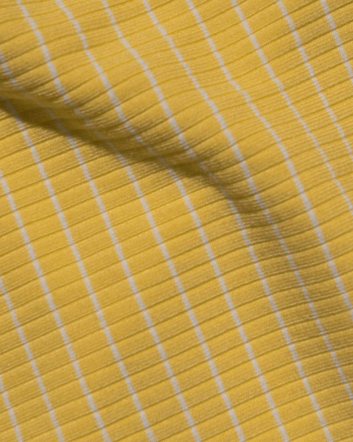 Samantha Dress - Limoncello Stripe A close-up of a yellow ribbed fabric with thin white stripes.