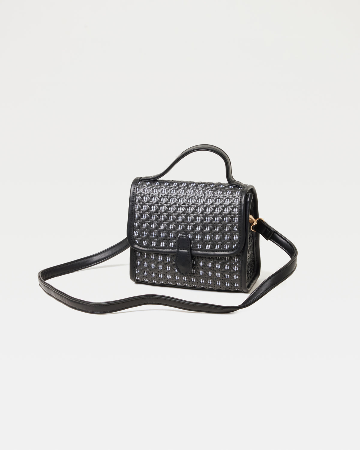 Off-model image of the Amelia Bag in black, a structured mini woven top-handle crossbody bag, with the crossbody strap extended.