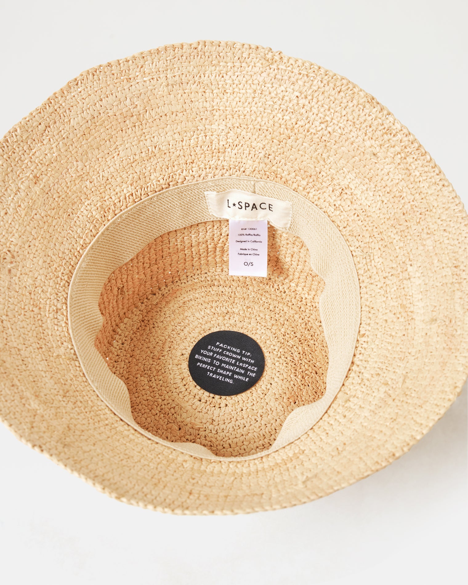 Carmel Island Hat - Natural Top-down interior view of the Carmel Island Hat in natural showing the LSPACE branding label and packing tip tag.
