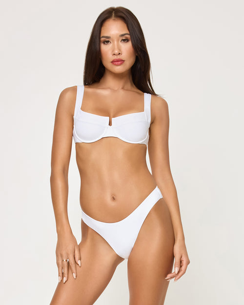 Front view of a model wearing the LSPACE white Mako Bikini Top, a structured underwire style with wide square-neck straps and center front hardware detail, paired with a matching white Rocky Bikini Bottom.