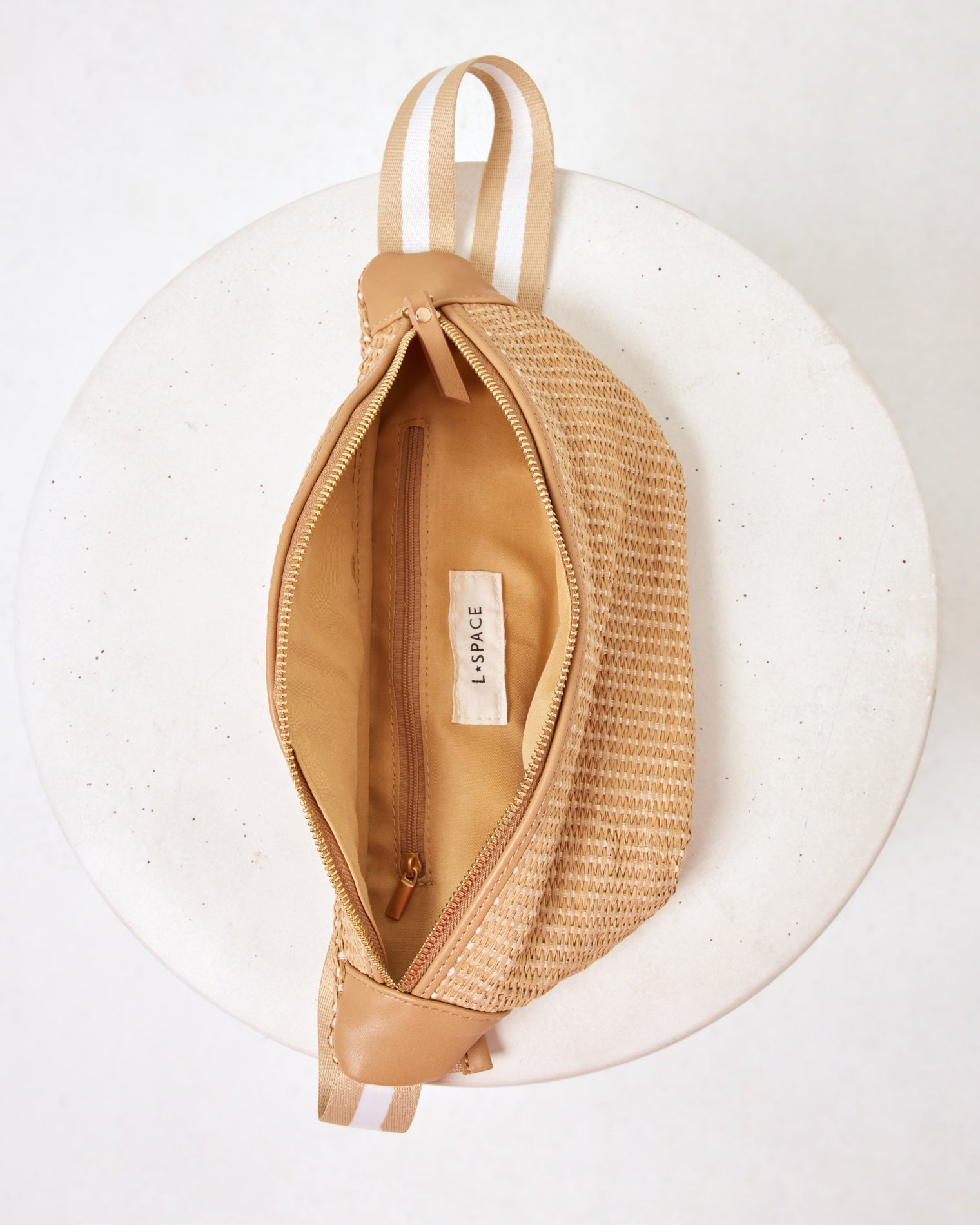 Evie Fanny Pack Interior view of the Evie Fanny Pack in natural, open and showing the LSPACE branded lining and inner zipper pocket.