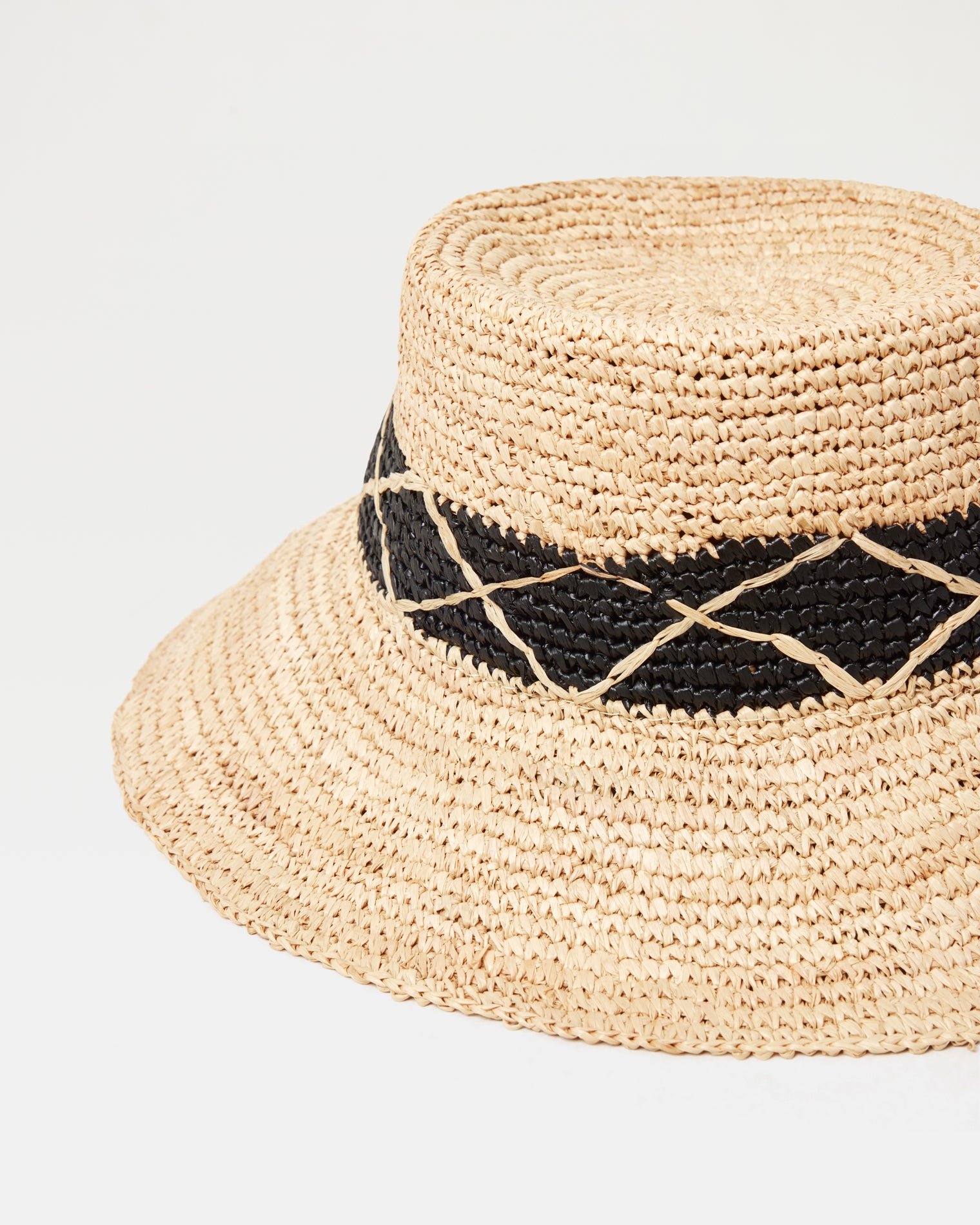 Montauk Bucket Hat - Natural Close-up of the Montauk Bucket Hat in natural showing the woven raffia texture and black diamond-patterned band detail.