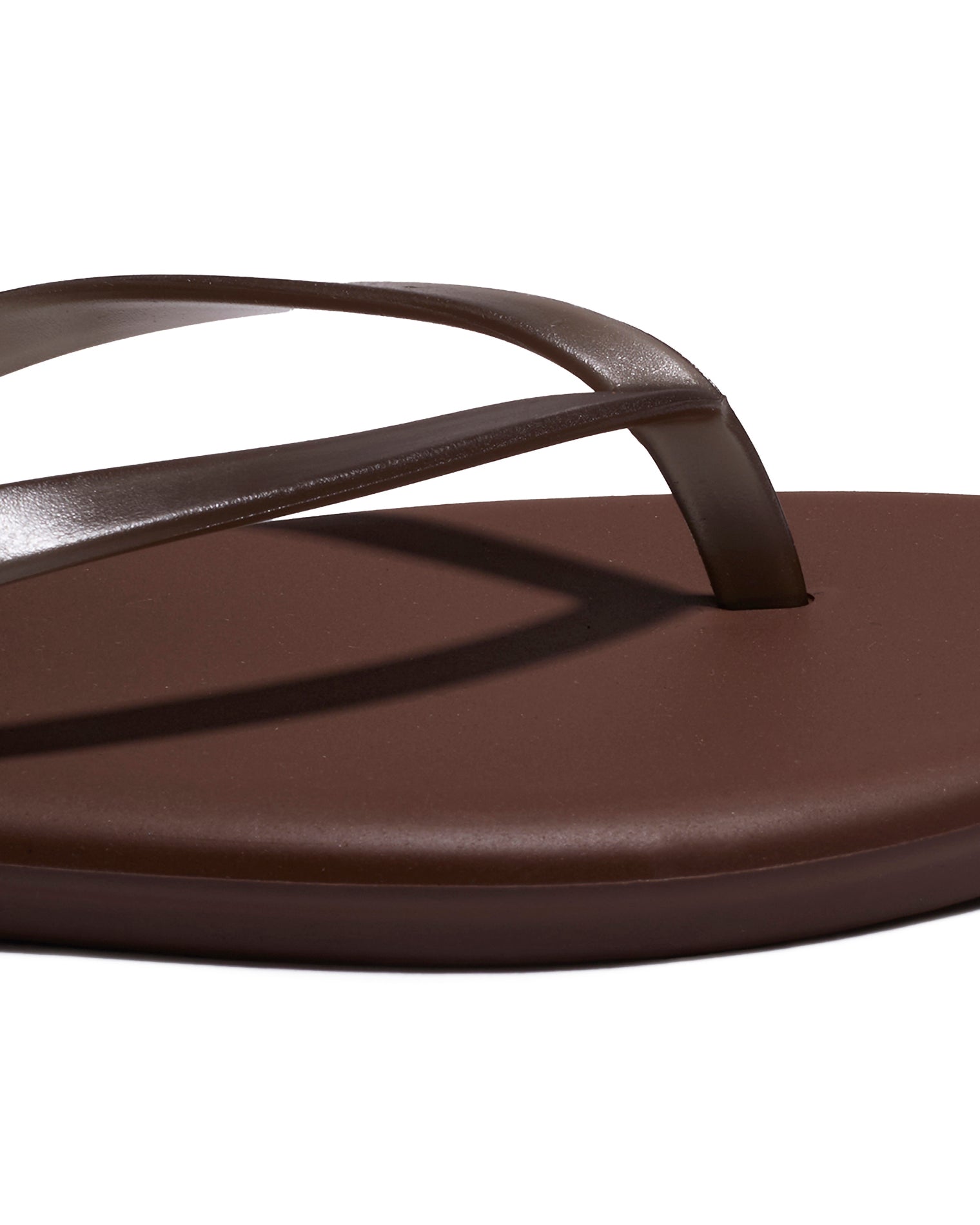 TKEES Aqua Sandals - Brown Close-up of the brown leather thong strap and footbed detail on the TKEES Aqua Sandals.