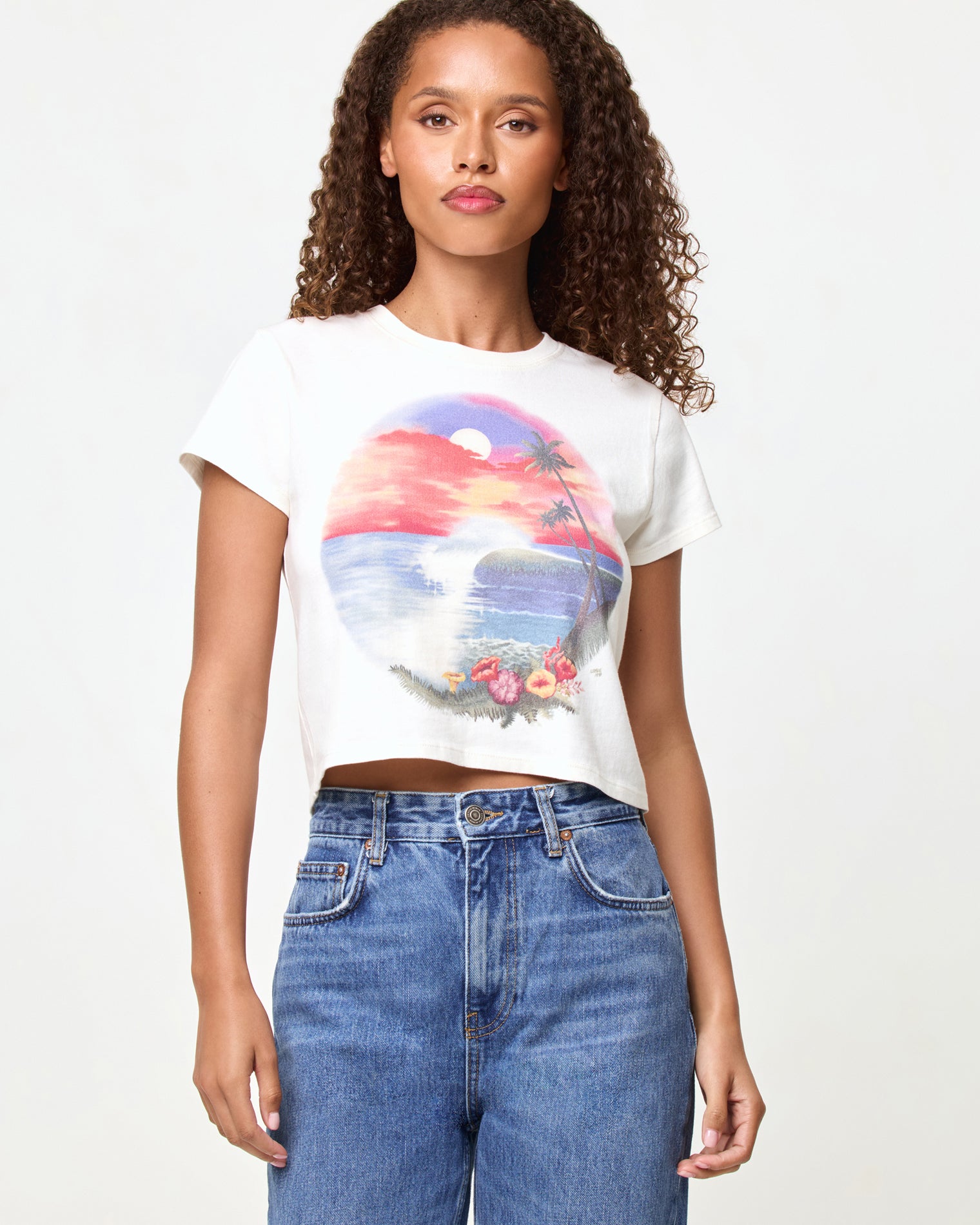 Merci Baby Tee - Airbrush Tourist Tee LSPACE Merci Baby Tee in airbrush tourist tee graphic, close-up front view on model styled with jeans.
