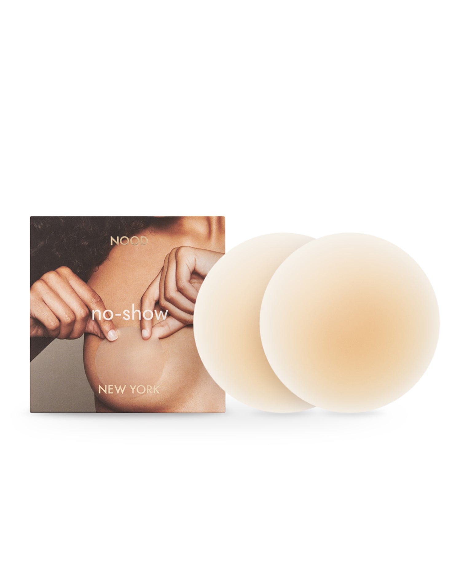 NOOD No Show Adhesive Nipple Covers - Buff Off-model image of the NOOD No Show Adhesive Nipple Covers in buff with the NOOD branded packaging box.