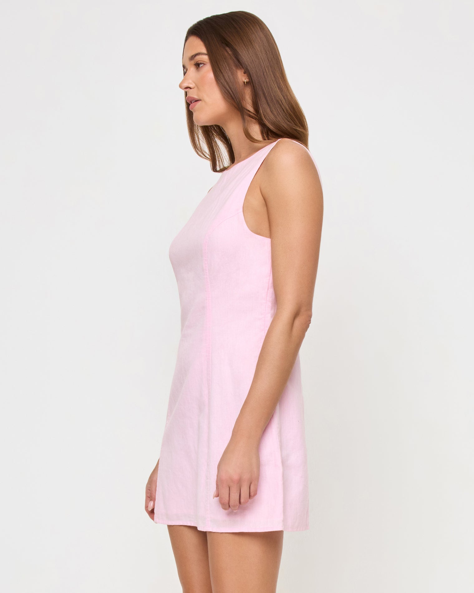 Oceanside Mini - Rosewater Side view of a model wearing the LSPACE Oceanside Mini in rosewater, a sleeveless mini dress with a fitted bodice and flared A-line skirt.