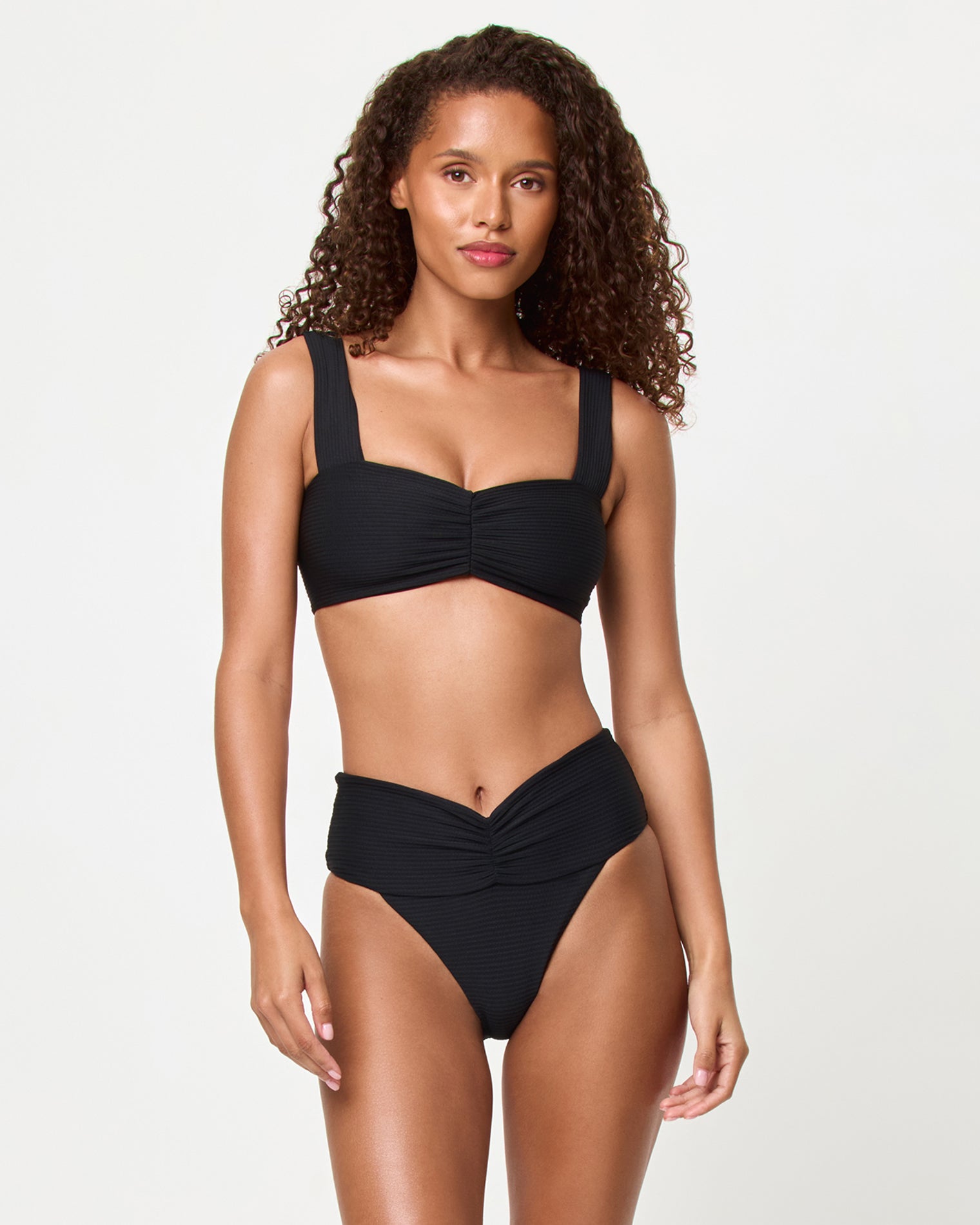 Marlee Bikini Top - Black Front view of a model wearing the LSPACE black Bardot Bikini Bottom, a ribbed high-waist style with gathered center front waistband detail, paired with the black Marlee Bikini Top.