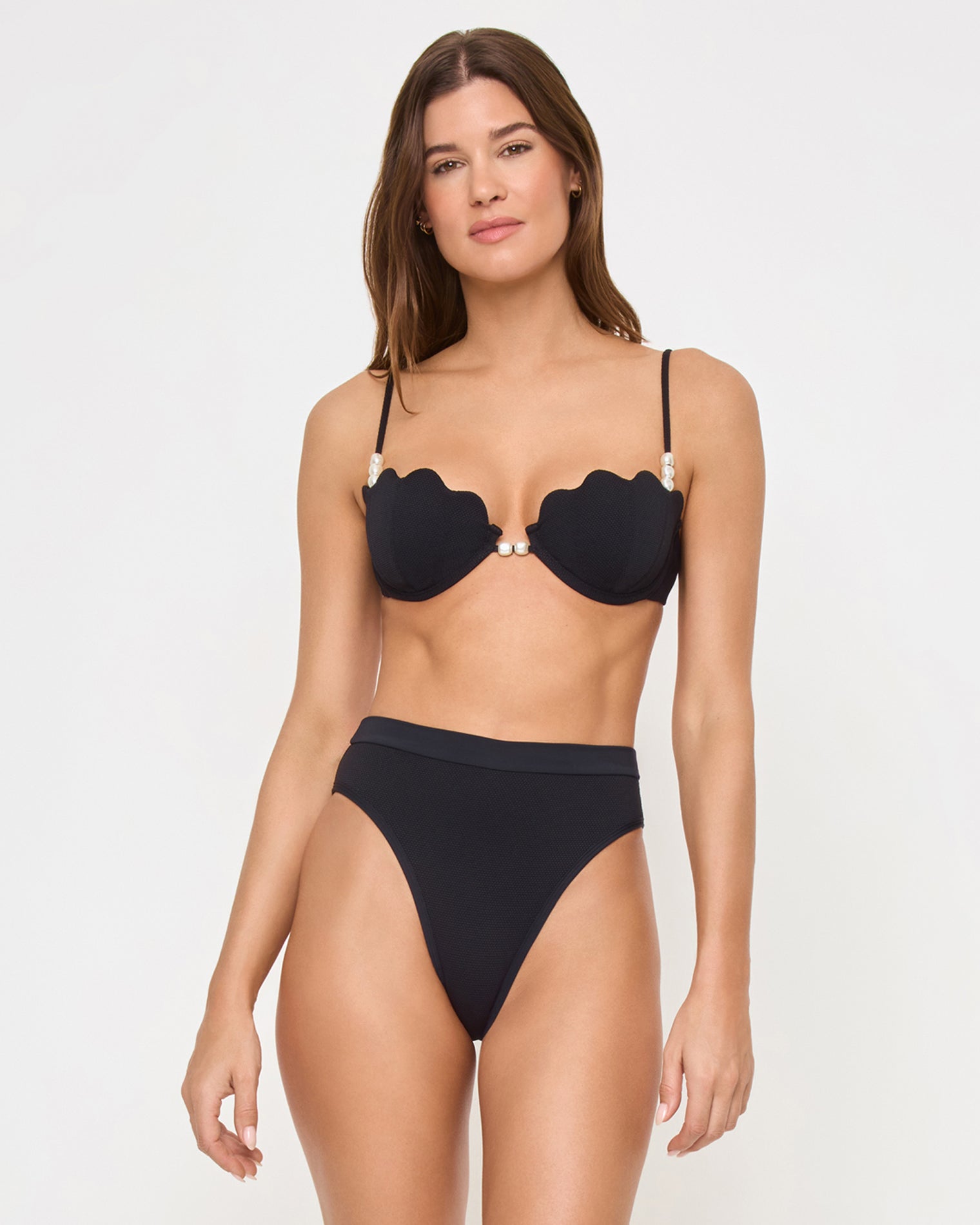 Sunrise Shell Bikini Top - Black Three-quarter front view of a model wearing the LSPACE black Sunrise Shell Bikini Top, a scalloped underwire style with pearl hardware, paired with a black high-waist Frenchi Bikini Bottom.