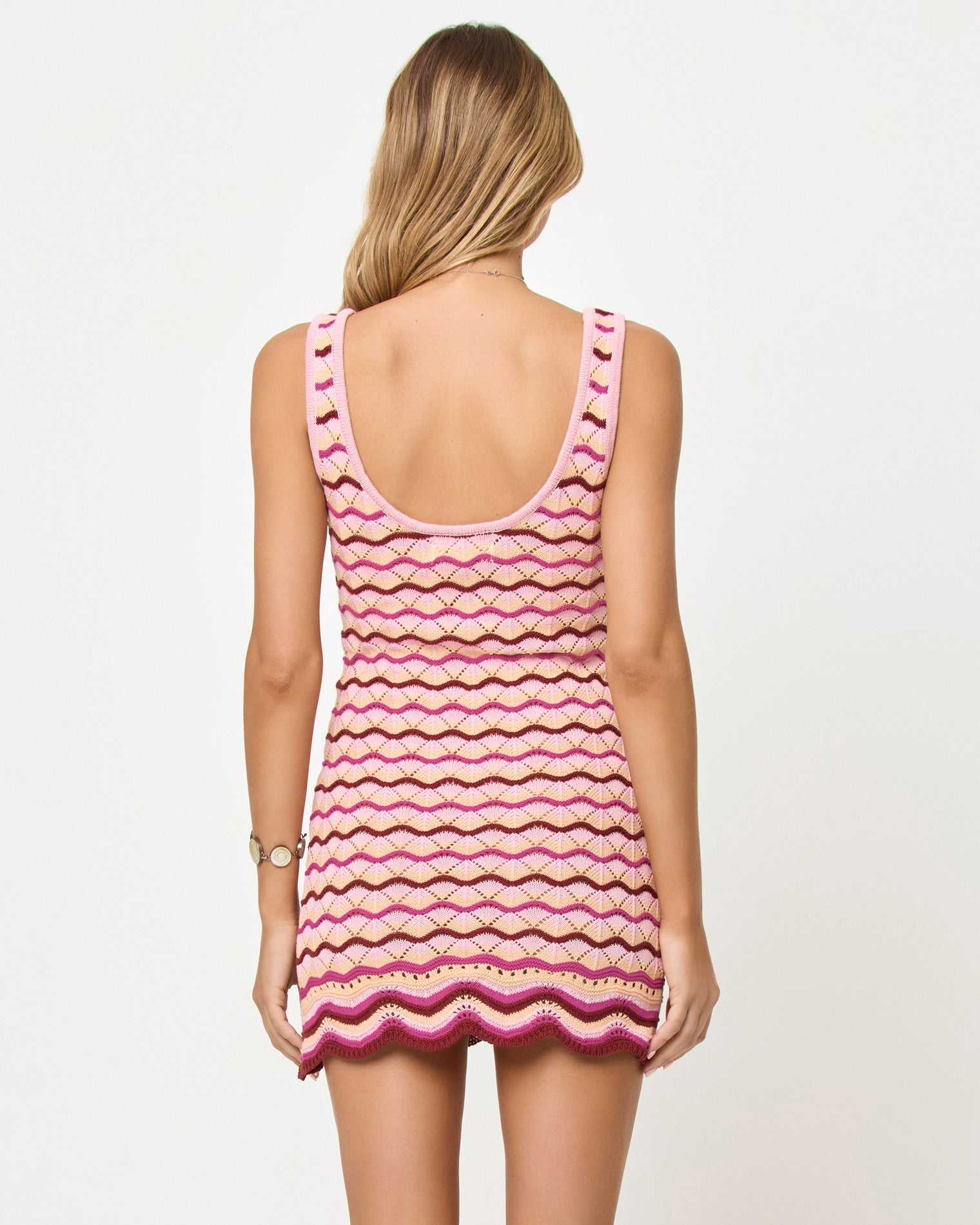 Sunchaser Dress - Berry Spritz Back view of model wearing the LSPACE Sunchaser Dress in berry spritz, a crochet mini dress.