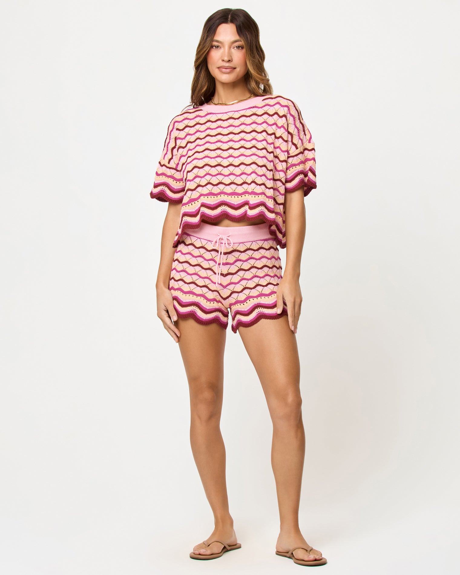 Sunchaser Short - Berry Spritz Berry Spritz | Badge:New Arrival_#B2AC88_#ffffff'
Front view of model wearing the LSPACE Sunchaser Short in berry spritz, a crochet mini short with scalloped hem in berry and pink tones, styled with matching top.
