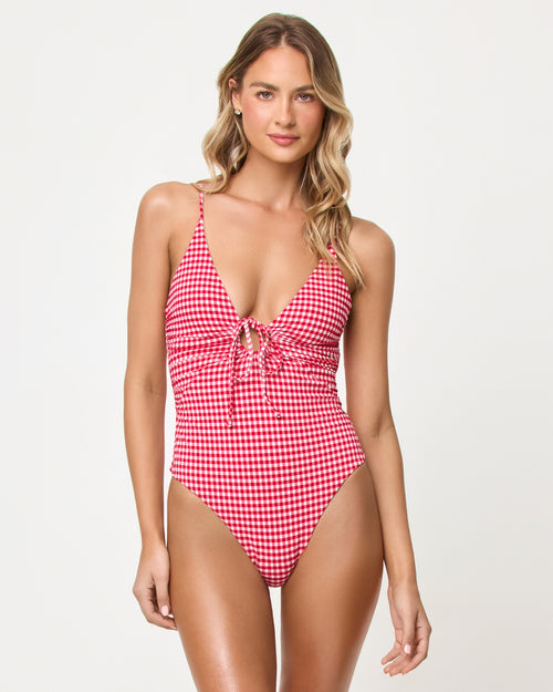 Front view of a model wearing the LSPACE lipstick red Piper One Piece Swimsuit in a red and white gingham print.