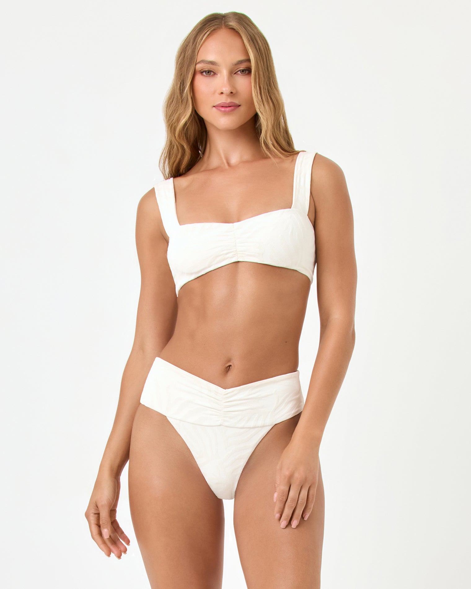 front view of woman wearing a white bikini on a plain background