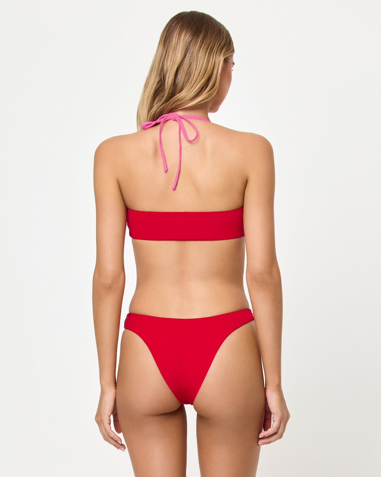 Rayne Bikini Top - Lipstick Red Sweetheart Back view of a model wearing the LSPACE Lipstick Red Sweetheart Rayne Bikini Top showing pink halter tie at the neck, paired with the Vega Bikini Bottom.