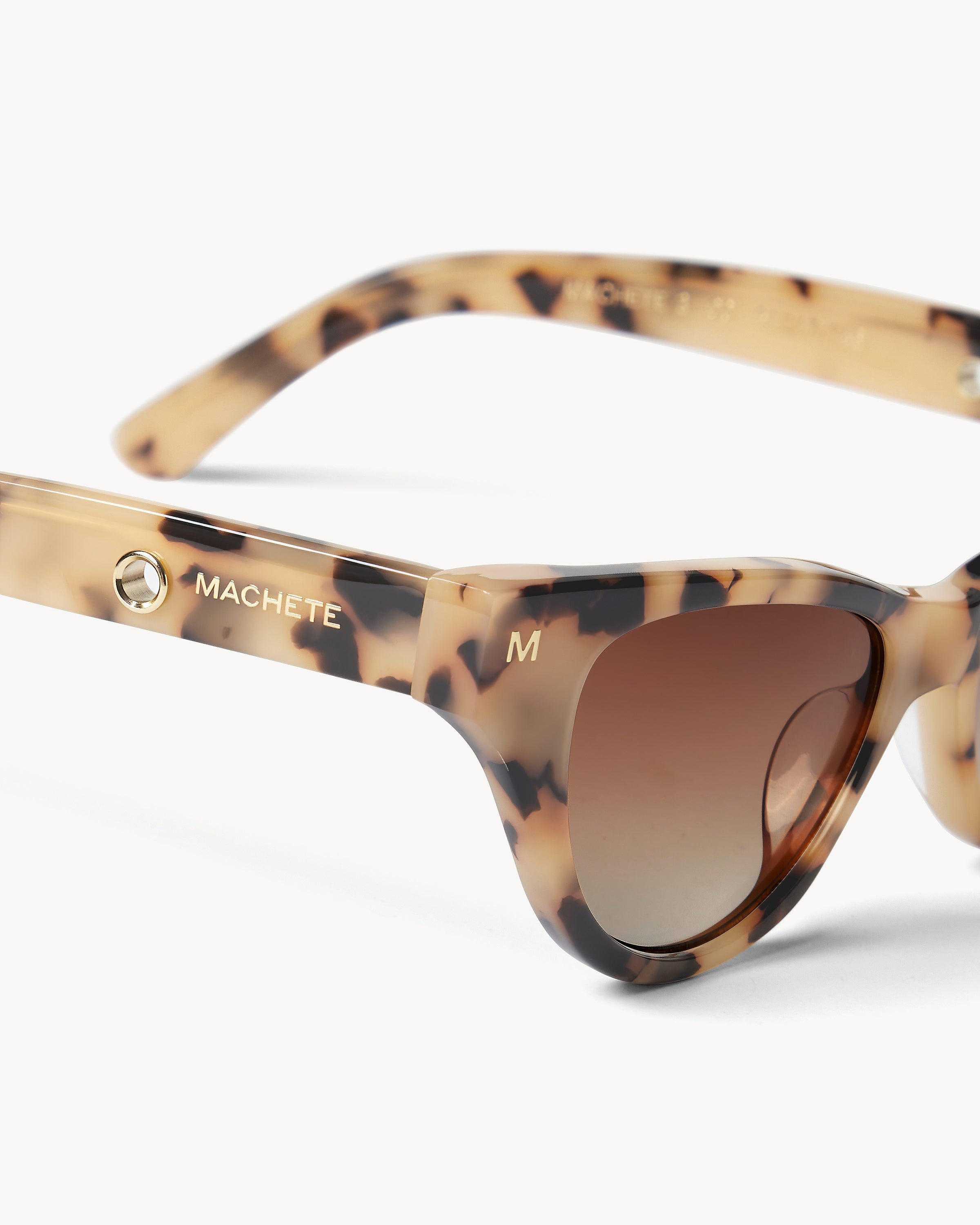 Machete Suzy Sunglasses - Blonde Tortoise Close-up detail of the Machete Suzy Sunglasses in blonde tortoise showing the Machete branding on the temple arm and the brown gradient lenses.