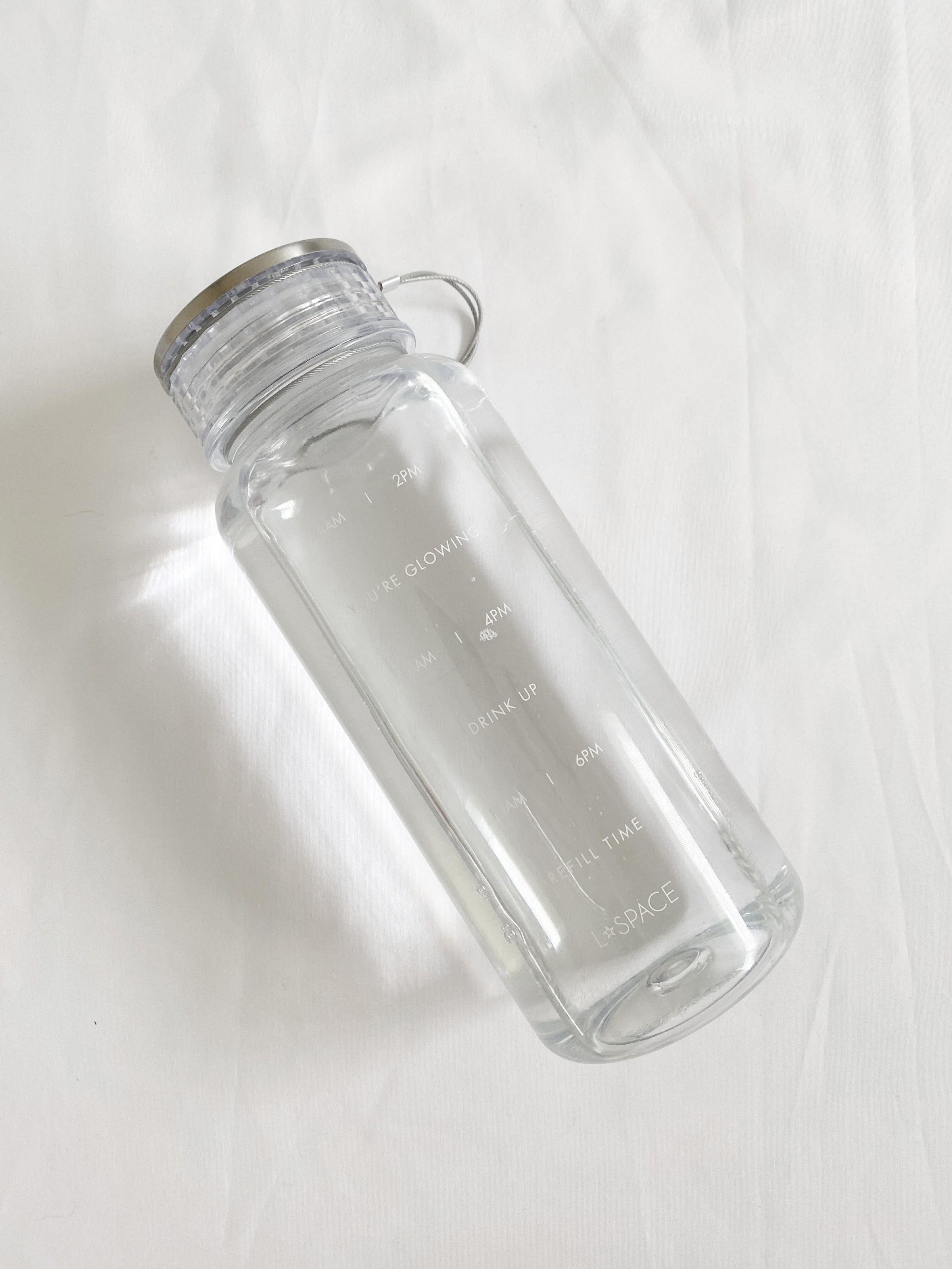 LSPACE Water Bottle LSPACE water bottle with wellness quotes, off-model flat lay.